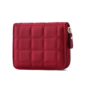 Détail du mini portefeuille rouge matelassé avec fermeture éclair et texture grainée