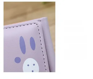 Gros plan des coutures délicates sur le portefeuille chat violet à motif de lapin