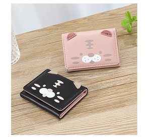 Gros plan de portefeuilles chat mignons en rose et noir sur un bureau en bois clair
