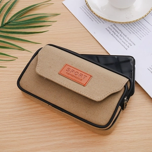 Detailed view of khaki canvas belt pouch with black piping and orange sport emblem