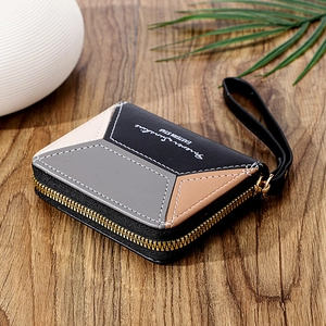 Detail of multi-color patchwork leather wallet with gold zipper on a wooden background