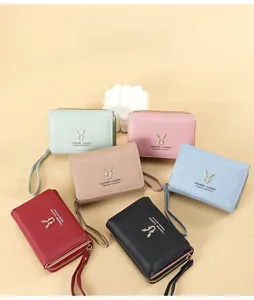 Flat lay view of multi-color PU leather wallets featuring gold deer head ornaments