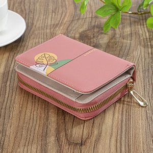 Close-up of pink PU leather wallet with floral print and zipper on wood background