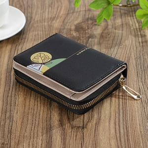 Detailed close-up of a small zip wallet with black and beige stitching and floral patterns