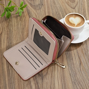 Close-up of pink and grey leather wallet with card slots, ID window and gold zipper