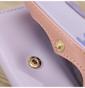 Détail du portefeuille en similicuir violet avec bordure rose et bouton pression étoile