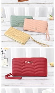 Detail of quilted long wallet for women with golden bow hardware and wristlet strap