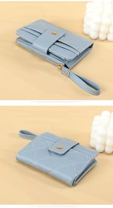 Close-up of light blue quilted wallet featuring multiple card slots and wrist strap
