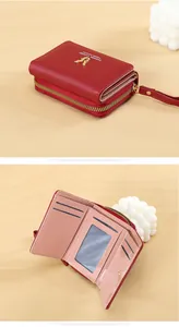 Detail of red PU leather tri-fold wallet with deer charm and multi-card slots