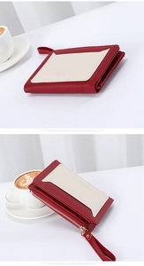 Detail of red and beige leather card holder with gold zipper and wrist strap