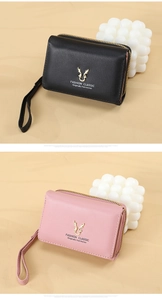 Detail of PU leather wallet with golden deer logo, zipper closure and wrist strap