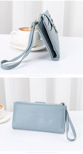 Detail of light blue quilted PU leather wallet with wrist strap and gold zipper