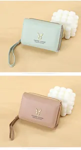 Detail of PU leather wallet with golden antler buckle and matching wrist strap