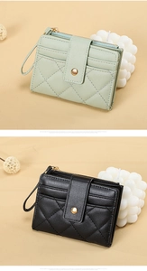 Close-up of quilted PU leather zip wallets with metallic gold hardware in green and black