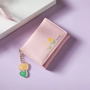 Close-up of pink tri-fold PU leather wallet with tulip charm and nice day print