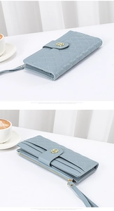 Detail of light blue quilted leather wallet featuring multi-card slots and wrist strap