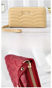 Detail of wave-stitched long wallet with golden bow and durable metal zipper closure