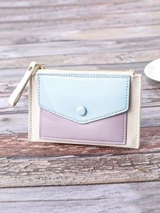 Slim tricolor leather card wallet with zip closure and button pocket on wood background