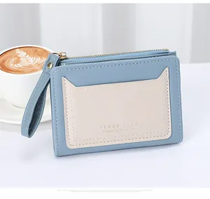 Detailed view of blue and beige leather coin purse with zipper and card slot on table