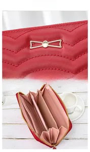 Macro detail of red quilted leather wallet with gold bow and functional interior compartments