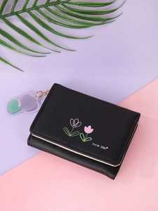 Detail of a black floral PU leather wallet with a heart-shaped acrylic charm and gold chain
