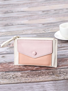 Close-up of tricolor patchwork wallet with envelope snap pocket and golden zipper