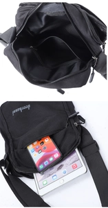 Detailed interior of black canvas crossbody bag with multi-layer zipper compartments