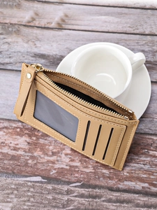 Slim khaki PU leather card holder with three card slots and a clear ID window on wood