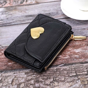 Detail of quilted black leather wallet with heart ornament and gold zipper hardware