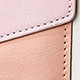 Close-up of color-block wallet featuring pink lychee grain leather and white stitching