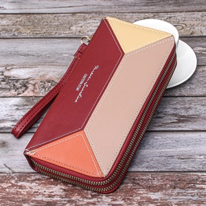 Macro detail of color-block double zipper wallet showing stitching and wrist strap