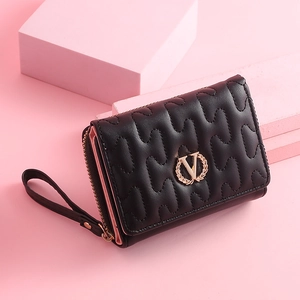 Close-up of black quilted leather trifold wallet with gold V logo and wrist strap