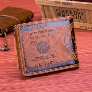 Detail of vintage leather wallet with embossed 100 dollar bill pattern on wood background