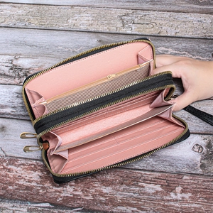 Detail of multi-layer wallet with double zippers, card slots and inner pink lining