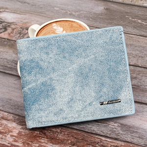 Slim men's denim fabric wallet with bifold design and metal logo on a wooden surface