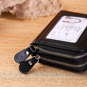 Close-up of black lychee grain leather card holder with dual zippers and clear ID window