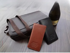 Classic leather wallets in black and brown with cross-body bag on wooden background