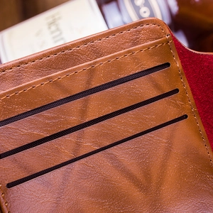 Close-up of brown pebbled leather wallet interior featuring three card slots and fine stitching
