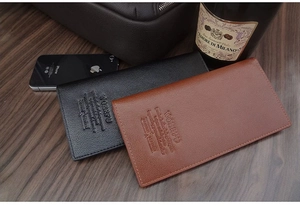Close-up of litchi grain texture on black and brown leather wallets for men
