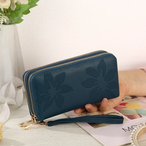 Detail of dark blue lychee grain leather wallet with floral embossing and dual gold zippers