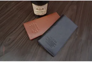 Close-up of black and brown genuine leather wallets with pebbled texture and business logo