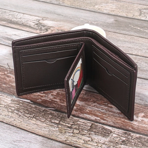 Detail of dark brown men's bi-fold wallet featuring multiple card slots and ID window
