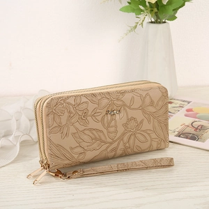 Detail of beige PU leather long wallet with embossed floral patterns and dual zippers