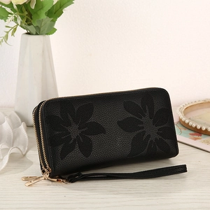 Detail of black faux leather wallet with floral embossing and double zipper design