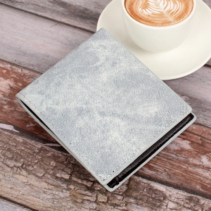 Short denim texture men's wallet placed on a wooden floor next to a latte coffee cup