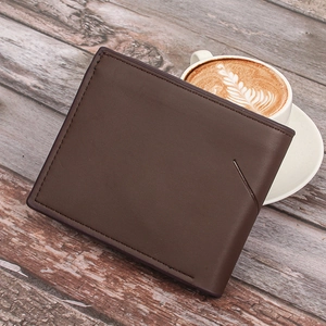 Detailed view of dark brown leather wallet with contrast stitching on wooden table background