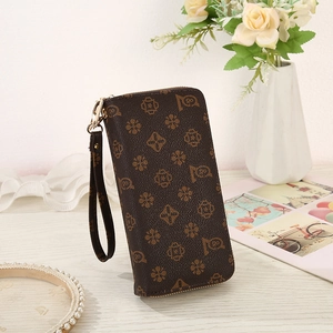 Detail of vintage long wallet with brown floral pattern on wooden surface background