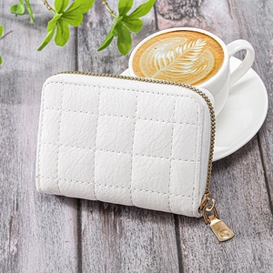 Elegant white quilted faux leather mini wallet with gold zipper on gray wooden table