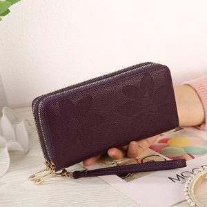 Detail of deep purple long wallet with floral embossing and double zipper feature