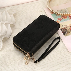 Close-up of black double zipper wallet with embossed floral pattern and wrist strap
